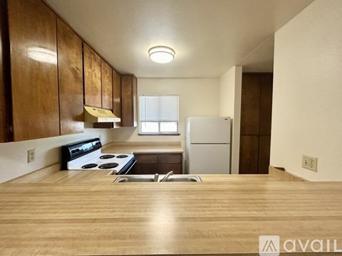A kitchen with wooden cabinets and a white refrigerator.