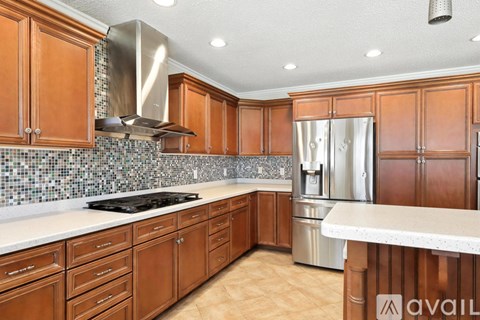 A kitchen with wooden cabinets and a stainless steel refrigerator.