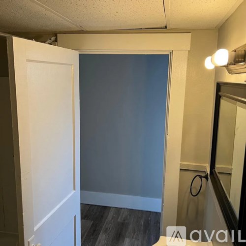 A room with a white door and a mirror on the wall.
