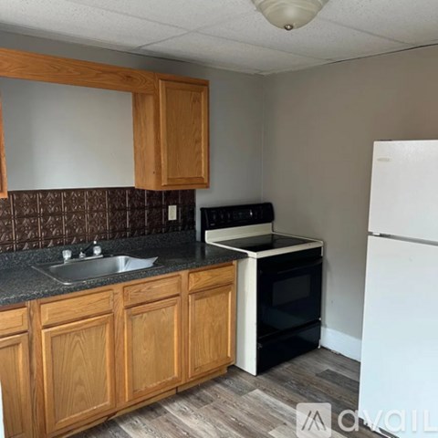 A kitchen with wooden cabinets and a black stove top oven.