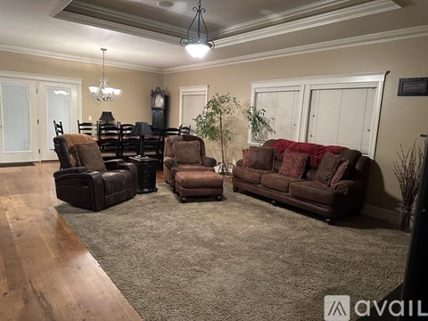 A living room with brown furniture and a chandelier.