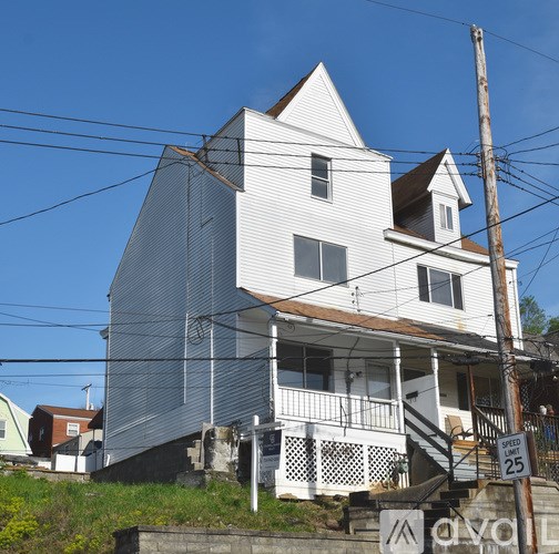A white house with a porch and a sign that says 25.