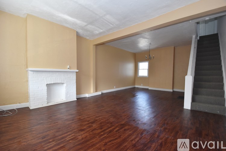 A room with a fireplace and wooden floors.
