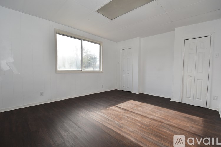 A room with wooden flooring and white walls.