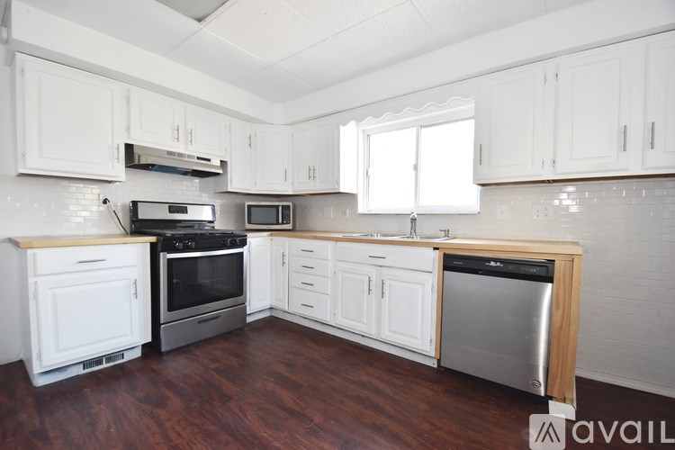 A kitchen with white cabinets and a wooden island.