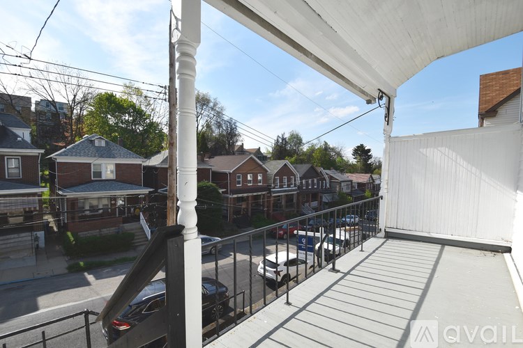 A balcony with a metal railing and a white column.