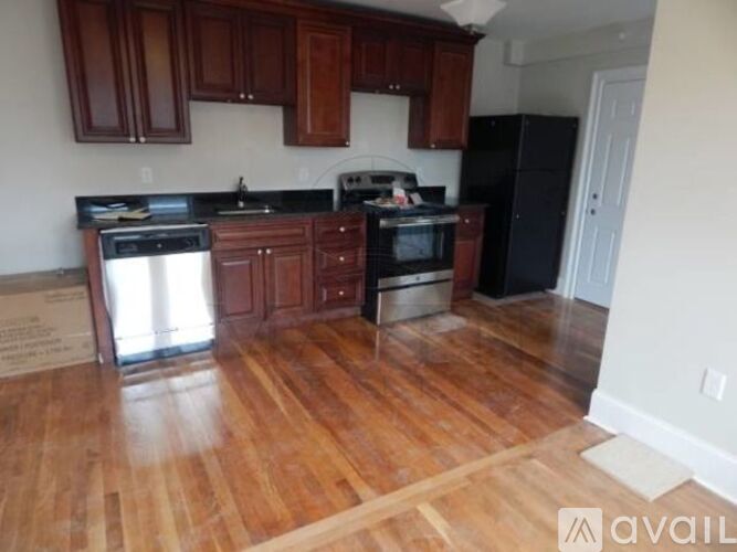 A kitchen with wooden cabinets and black appliances.