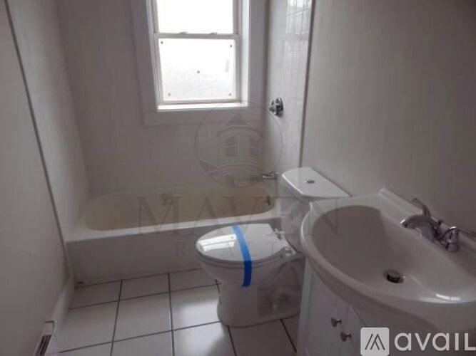 A white bathroom with a toilet, sink and tub.