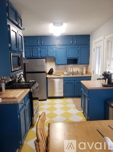 A kitchen with blue cabinets and a yellow and white checkered floor.