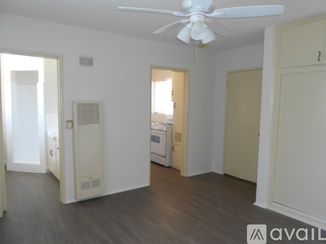 A room with a fan and a washing machine.