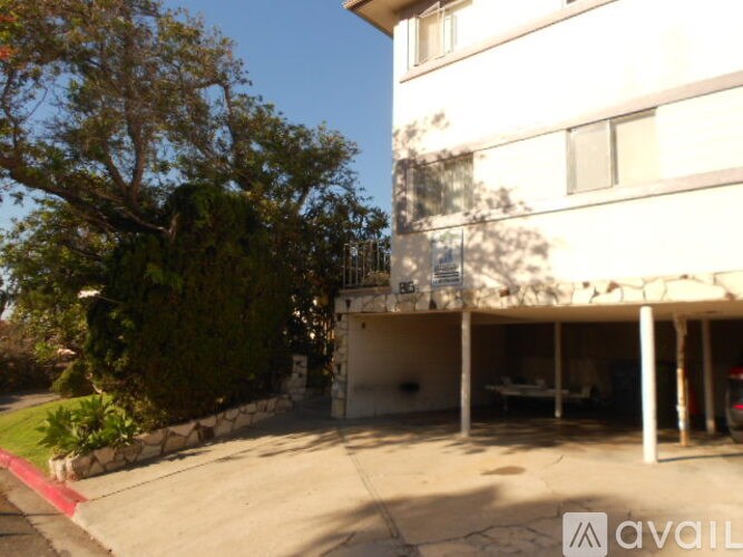 A building with a balcony and a tree in front of it.