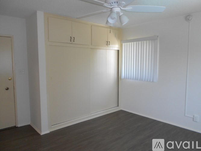 A room with a ceiling fan and a window with blinds.
