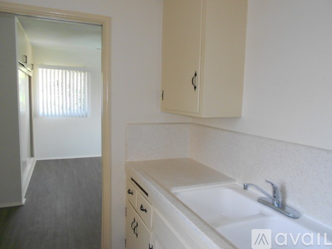 A bathroom with a sink, mirror, and cabinets.