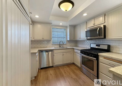 A kitchen with white cabinets and a black stove top oven.