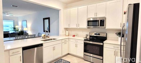 A white kitchen with a fridge on the right.