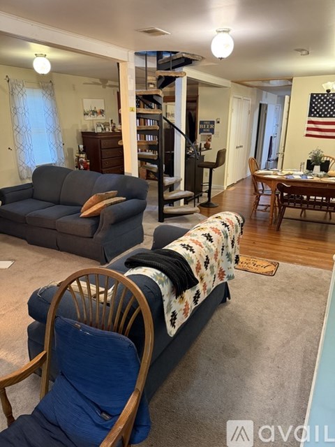 A living room with a grey couch and a wooden chair.