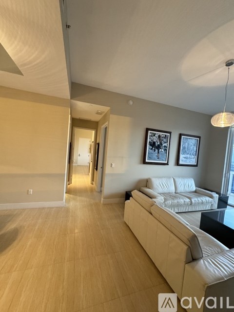 A living room with a white couch and a wooden floor.