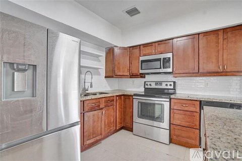 A kitchen with wooden cabinets and stainless steel appliances.