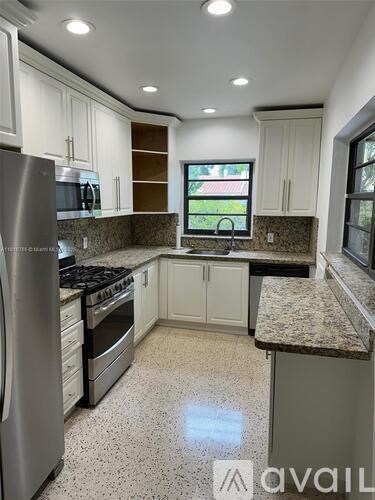 A kitchen with granite countertops and stainless steel appliances.