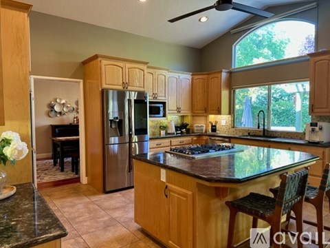 A kitchen with wooden cabinets and a black countertop.