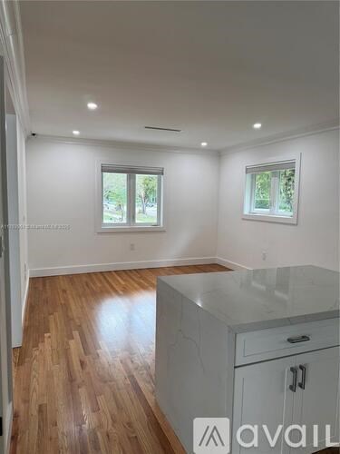 A kitchen with wooden floors and white walls.
