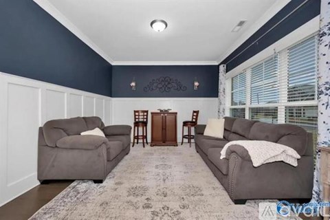 A living room with two grey couches and a rug.