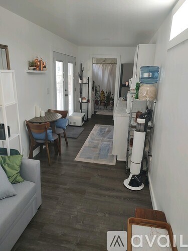 A living room with a grey couch and a white fridge.