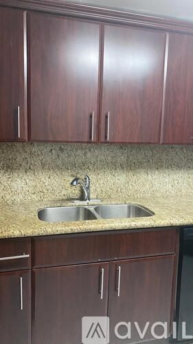 A kitchen with brown cabinets and a granite countertop.