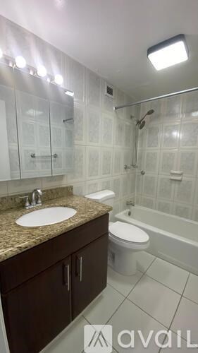 A bathroom with a sink, toilet, and bathtub.