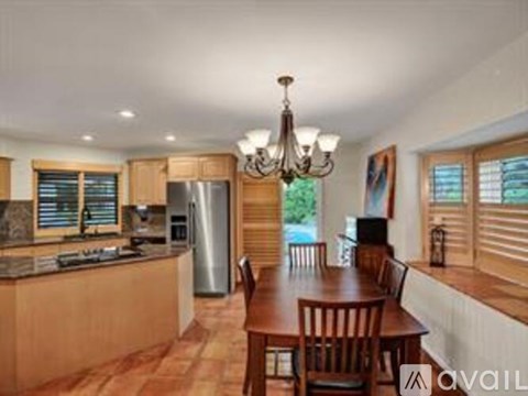 A kitchen with wooden cabinets and a dining table with chairs.