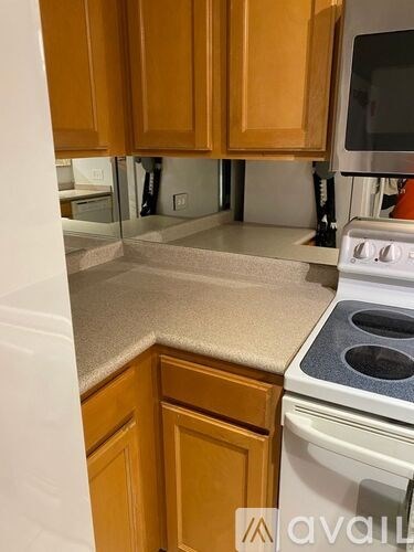 A kitchen with wooden cabinets and a white stove top oven.