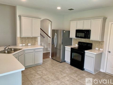 A kitchen with white cabinets and a black oven.