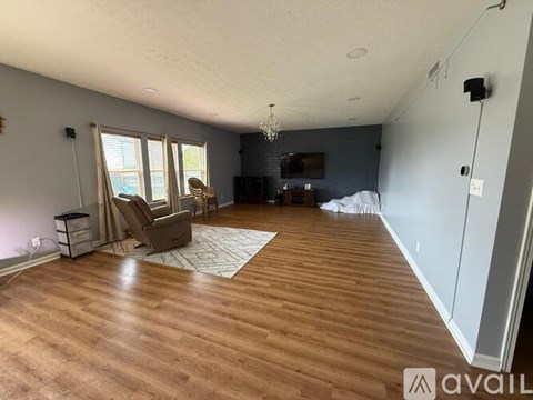 A living room with a brown rug and a brown chair.
