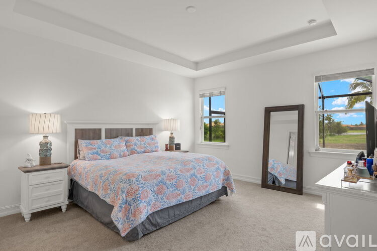 A bedroom with a bed, nightstands, and a window.