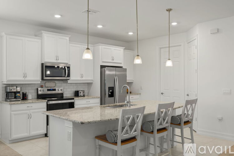 A kitchen with white cabinets and a granite countertop.