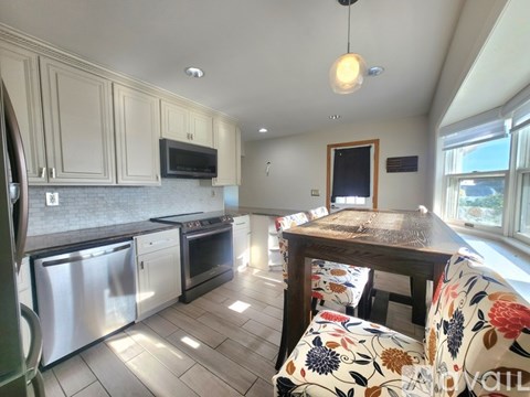 A kitchen with a table and chairs in front of a window.