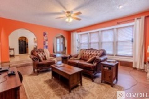 A living room with a brown leather couch and a wooden coffee table.