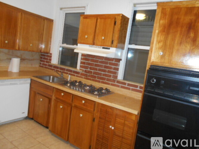 A kitchen with wooden cabinets and a brick backsplash.