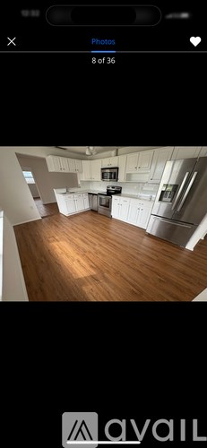 A kitchen with white cabinets and a wooden floor.