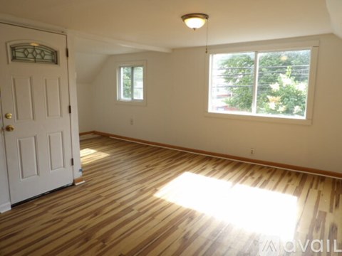 A room with wooden flooring and a white door.
