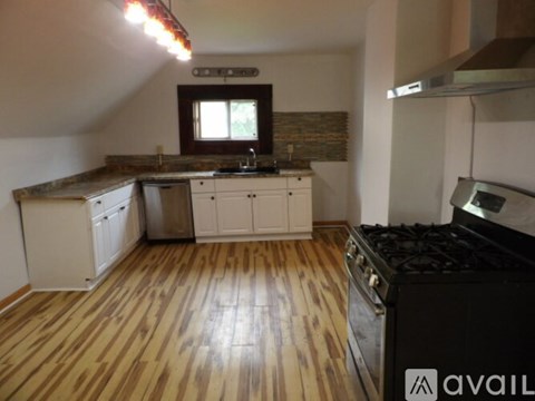 A kitchen with wooden floors and white cabinets.