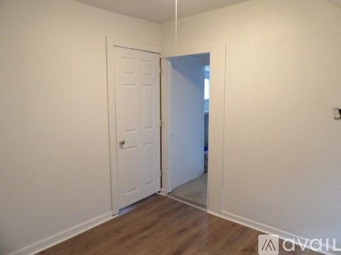 A room with a white door and a white wall.