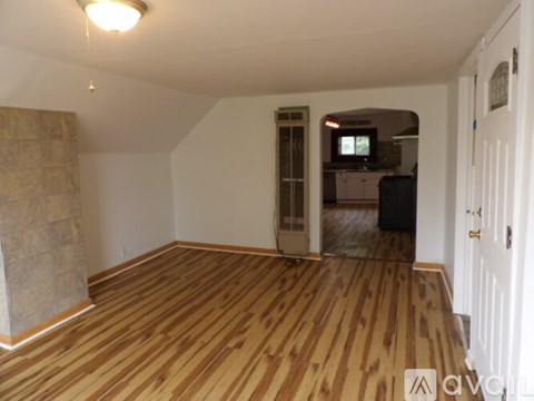 A room with wooden flooring and a white door.