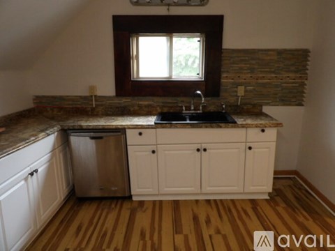 A kitchen with wooden floors and white cabinets.