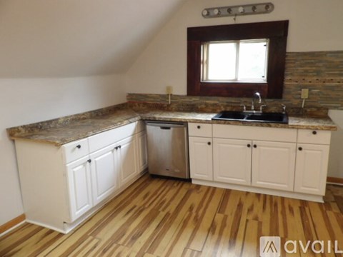 A kitchen with wooden floors and white cabinets.