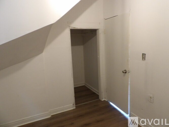 A hallway with a door on the right and a staircase on the left.
