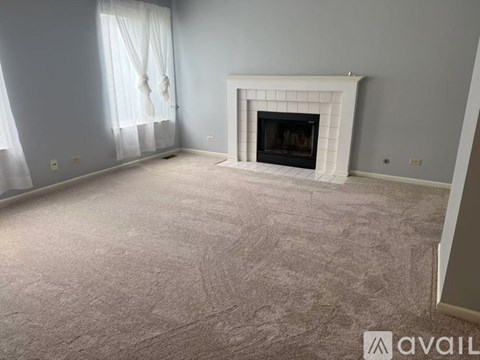 A living room with a fireplace and a carpeted floor.