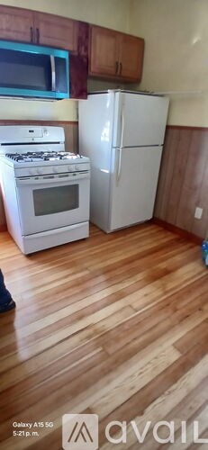 A kitchen with a white stove and refrigerator.