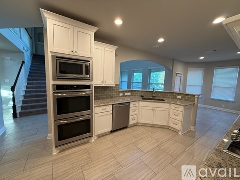 A modern kitchen with a stainless steel oven and white cabinets.