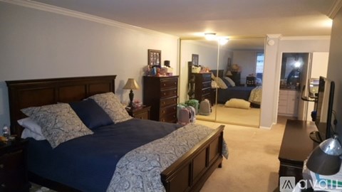 A bedroom with a bed, nightstand, and a mirror.